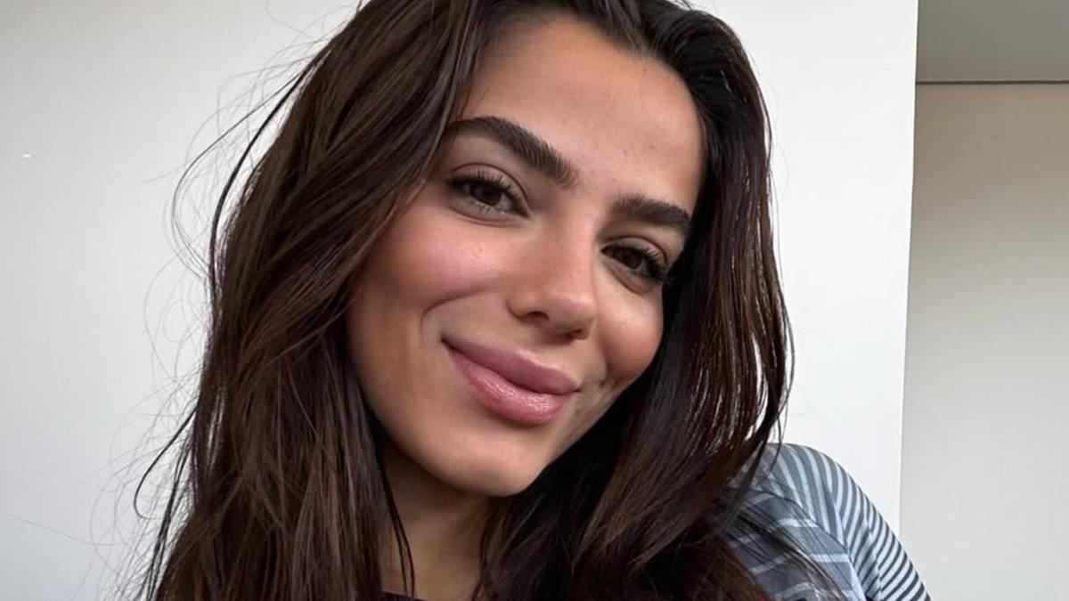 Portret kobiety z ciemnymi włosami, uśmiechającej się.