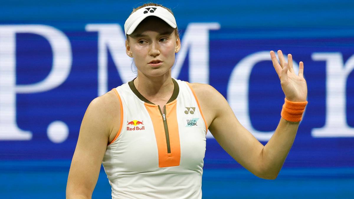 Tenisistka Jelena Rybakina z rakietą w ręku, w białej sukience, podczas meczu na korcie.