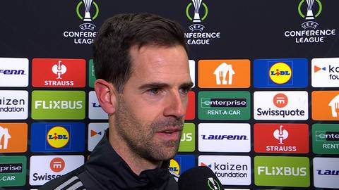 Portret Inakiego Astiza, trenera piłkarskiego, na tle ścianki z logo Ligi Konferencji i sponsor&oacute;w.