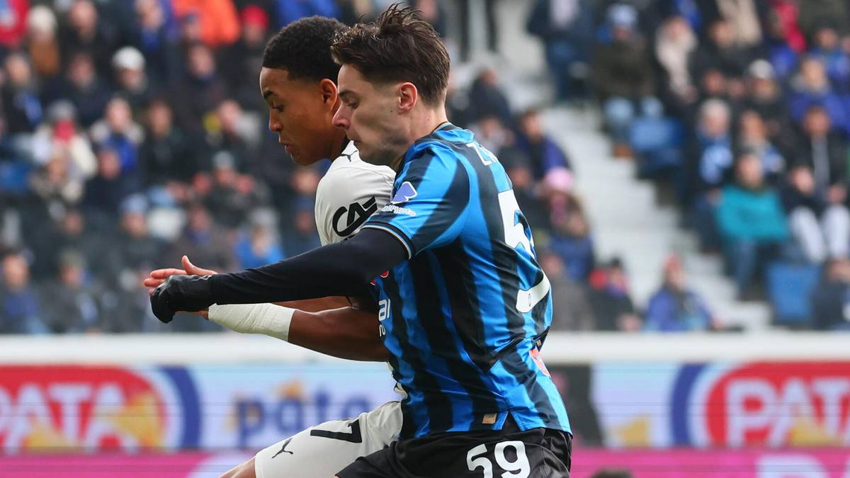 Piłkarz w niebiesko-czarnej koszulce z numerem 59 na plecach prowadzi piłkę.