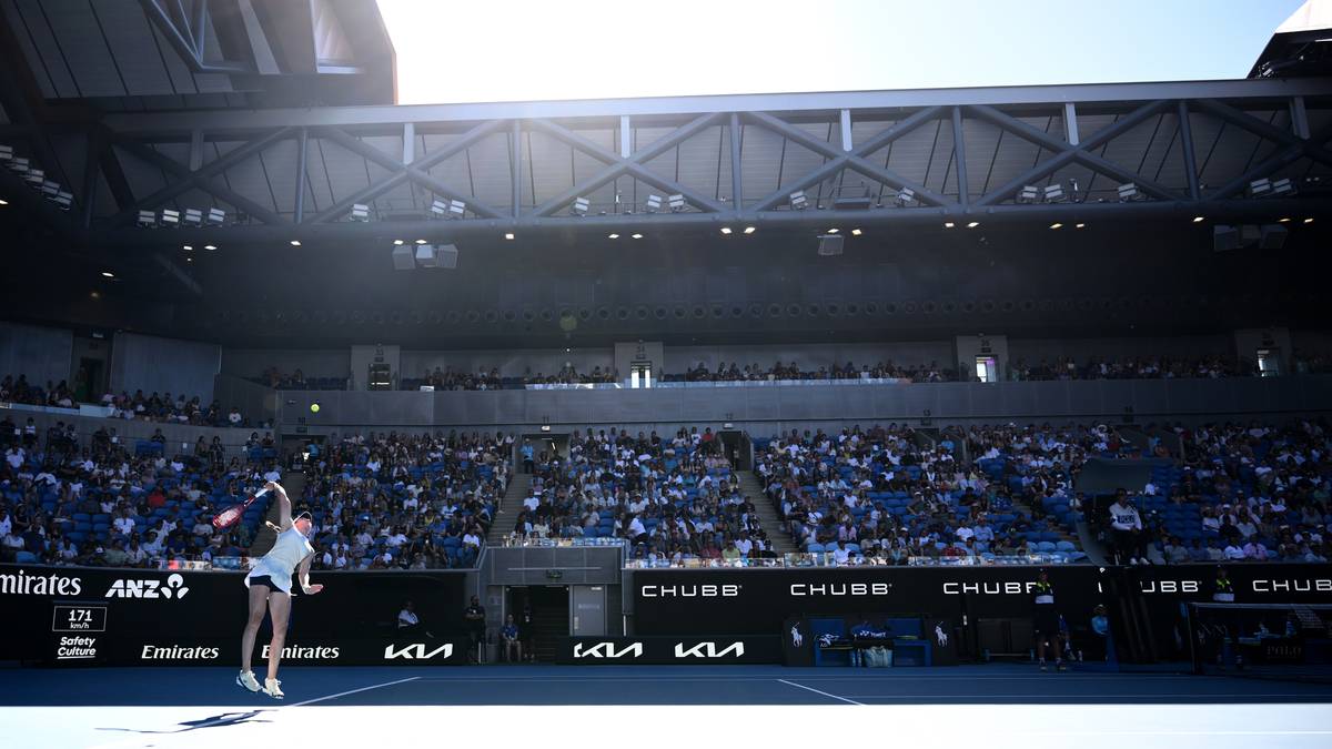 Tenisistka na korcie podczas meczu na Australian Open, w tle trybuny z widzami.