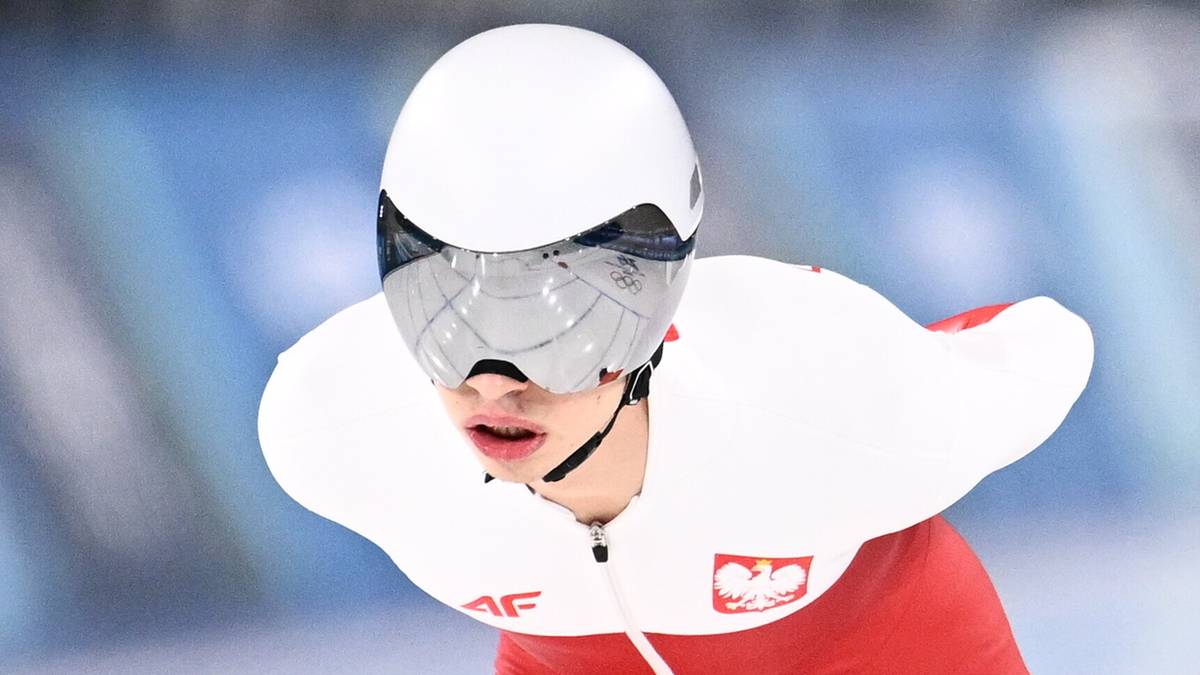 Łyżwiarz szybki w stroju reprezentacji Polski podczas jazdy na lodowisku.