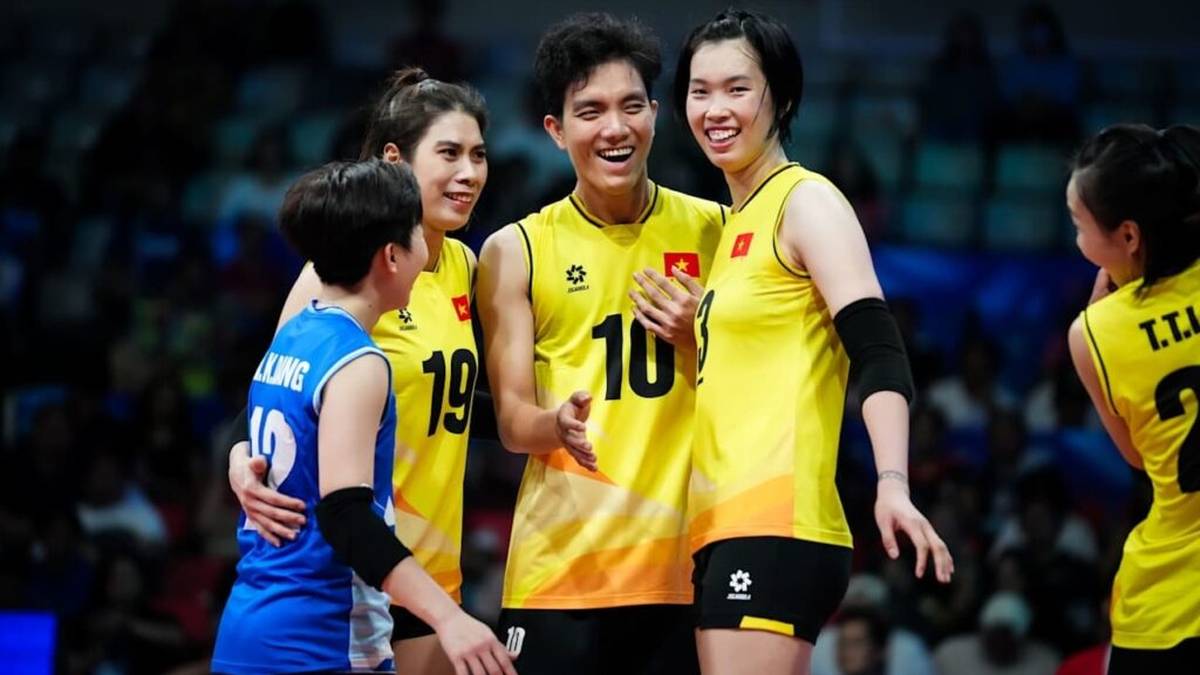 Grupa zawodników siatkówki w żółtych strojach, szczęśliwi i rozmawiający ze sobą podczas meczu.