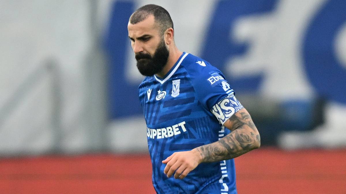 Piłkarz Lecha Poznań w niebieskim stroju z numerem 9 na koszulce prowadzi piłkę.