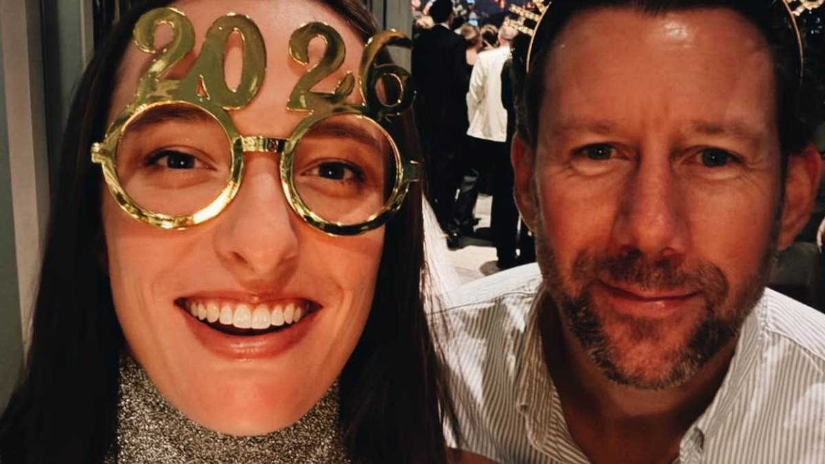 Kobieta i mężczyzna pozują do zdjęcia w okularach z napisem "2020" i "Happy New Year". W tle widać fajerwerki.