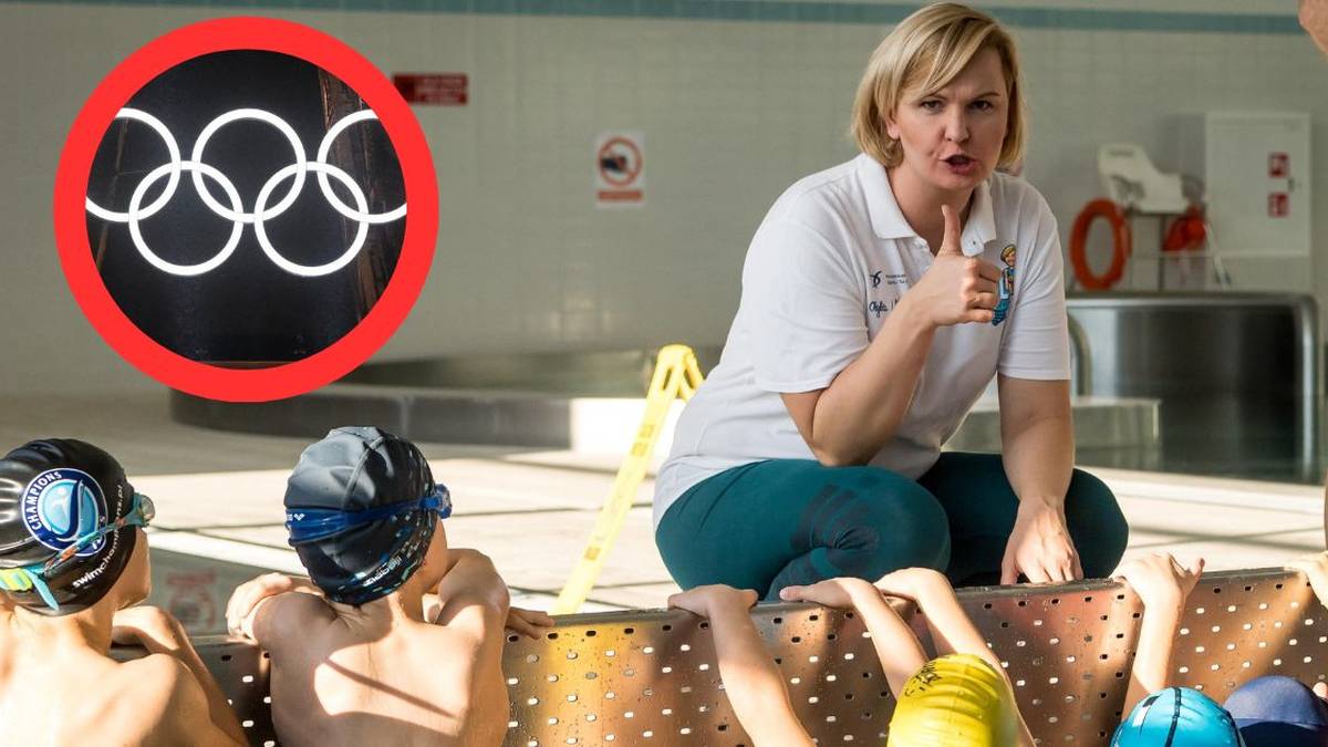 Otylia Jędrzejczak, mistrzyni olimpijska i prezes Polskiego Związku Pływackiego, siedzi na brzegu basenu z grupą młodych pływaków, obok widnieje symbol kół olimpijskich.
