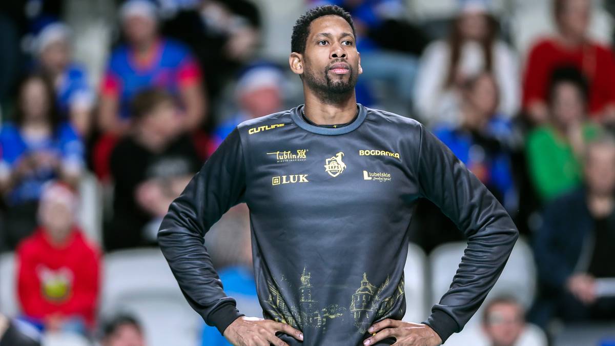 Siatkarz w czarnej koszulce z logo klubu i złotymi zdobieniami na boisku.