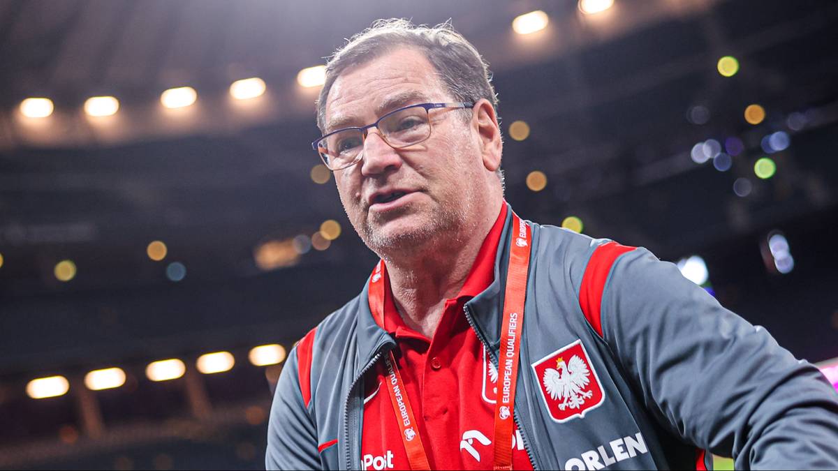 Portret mężczyzny w okularach w stroju reprezentacji Polski, w tle stadionowe oświetlenie.