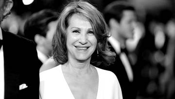 Portret Nathalie Baye, francuskiej aktorki, uśmiechniętej na tle innych os&oacute;b.