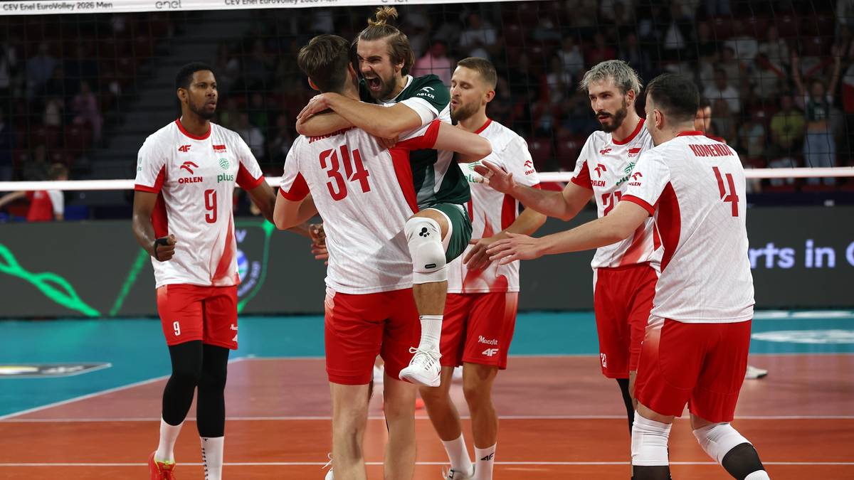 Siatkarze w biało-czerwonych strojach celebrujący zdobyty punkt na boisku.