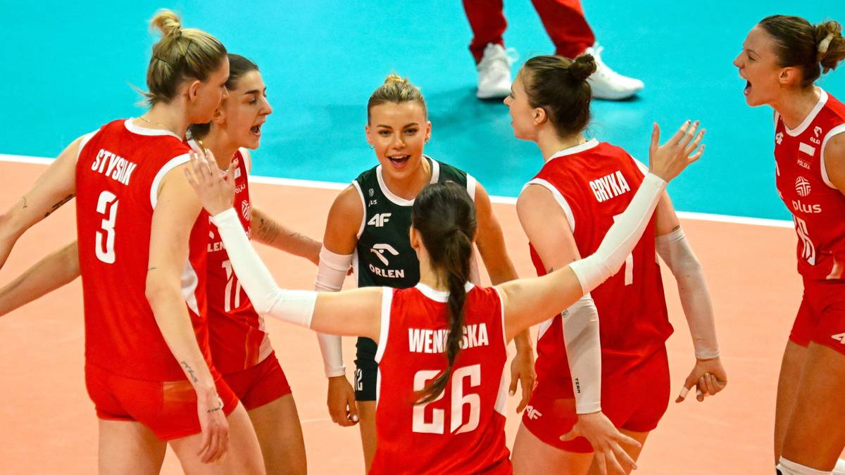 Graczki reprezentacji Polski w siatkówce w czerwonych strojach świętują zdobyty punkt, trzymając się za ręce.