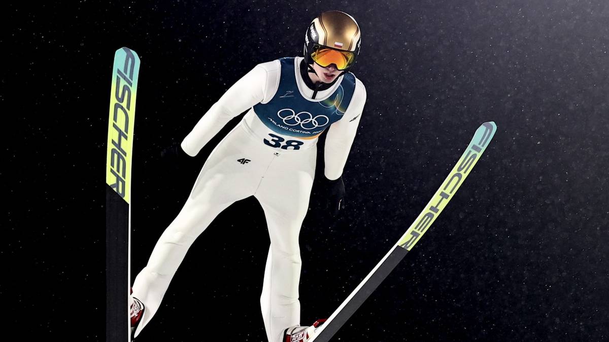 Skoczek narciarski Kacper Tomasiak w trakcie lotu na nartach.