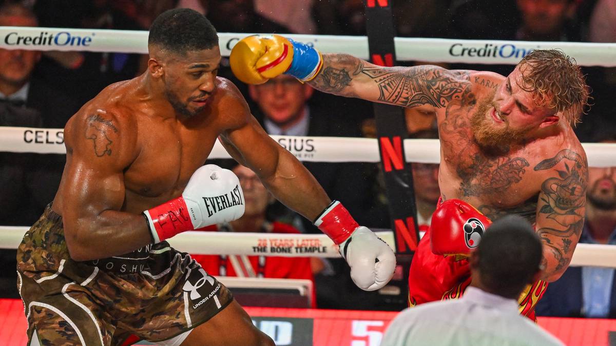 Dw&oacute;ch bokser&oacute;w, Anthony Joshua i Jake Paul, walczy w ringu.