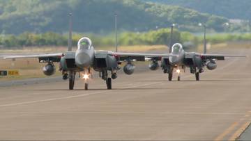 Dwa myśliwce wojskowe poruszające się po pasie startowym.