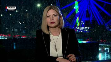Blondwłosa kobieta wypowiadająca się na tle nocnego miasta i neon&oacute;w, w lewym rogu grafika z napisem na żywo Krak&oacute;w.