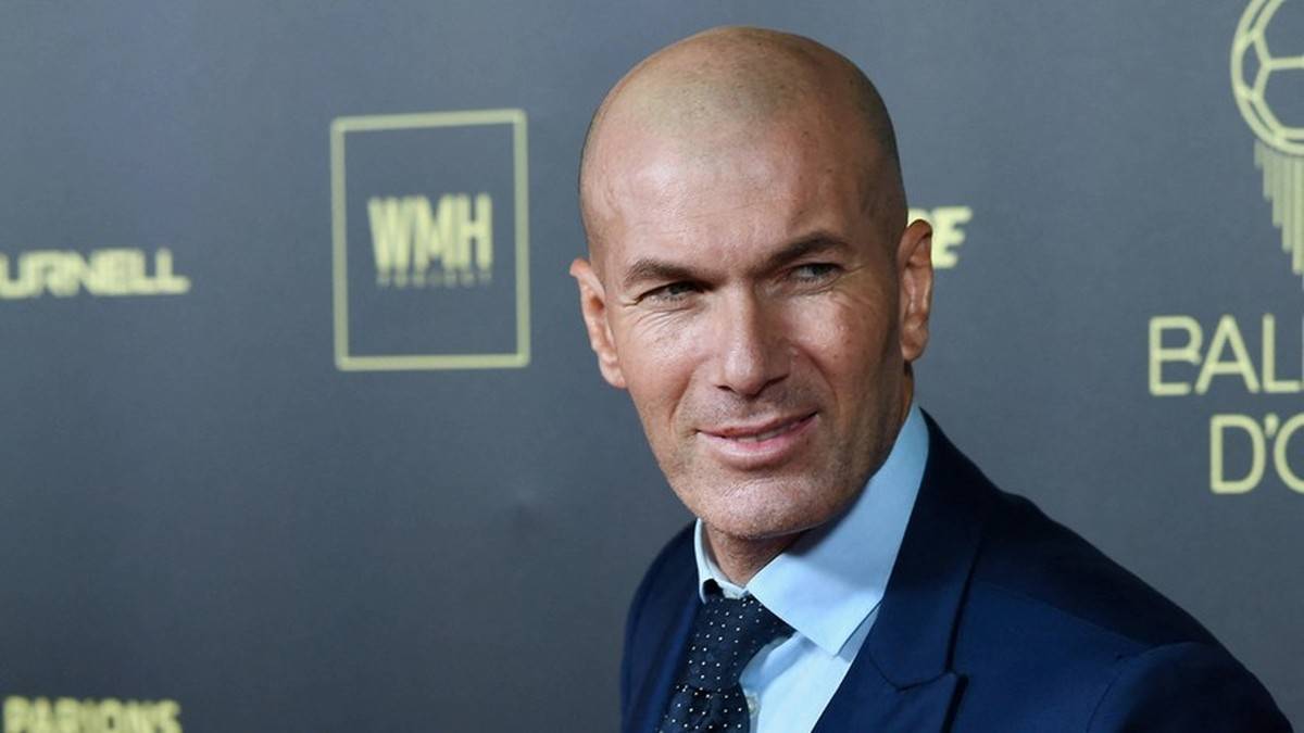 Zinedine Zidane, znany piłkarz i trener, w eleganckim garniturze.