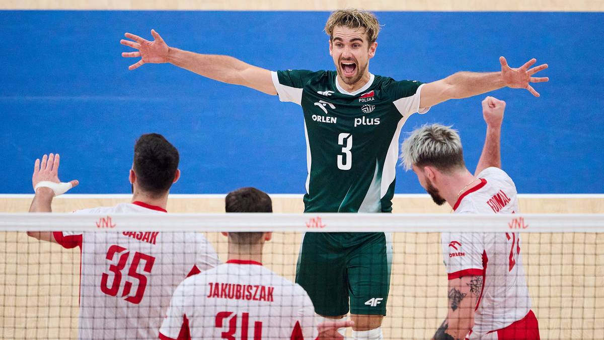 Siatkarz w zielonej koszulce z numerem 3 na plecach świętuje z podniesionymi rękami, otoczony przez kolegów z drużyny w białych koszulkach.