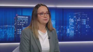 Kobieta w okularach i marynarce siedzi w studiu telewizyjnym.