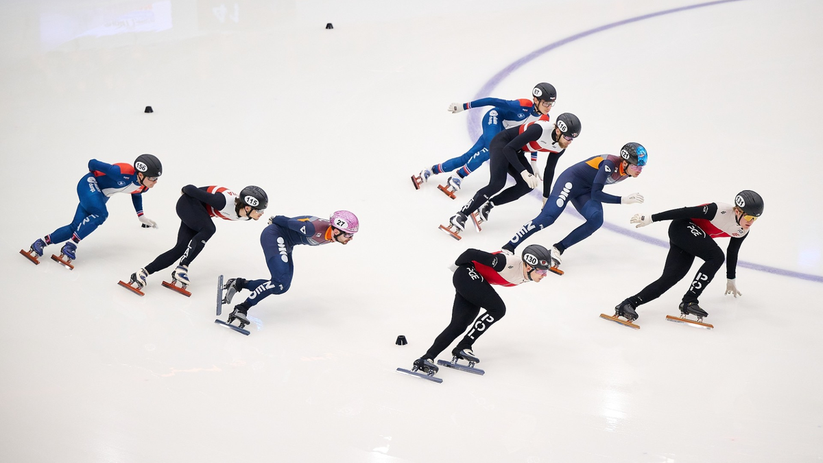 Grupa łyżwiarzy szybkich ścigających się na lodzie.