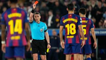 Sędzia pokazuje czerwoną kartkę piłkarzowi FC Barcelony podczas meczu.