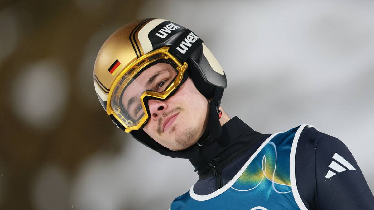 Skoczek narciarski w kasku i goglach, ubrany w str&oacute;j sportowy z numerem 45.