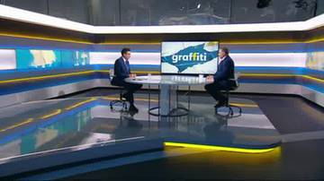 Dw&oacute;ch mężczyzn siedzi przy okrągłym stole w studiu telewizyjnym. Na ekranie za nimi wyświetlany jest napis "graffiti".