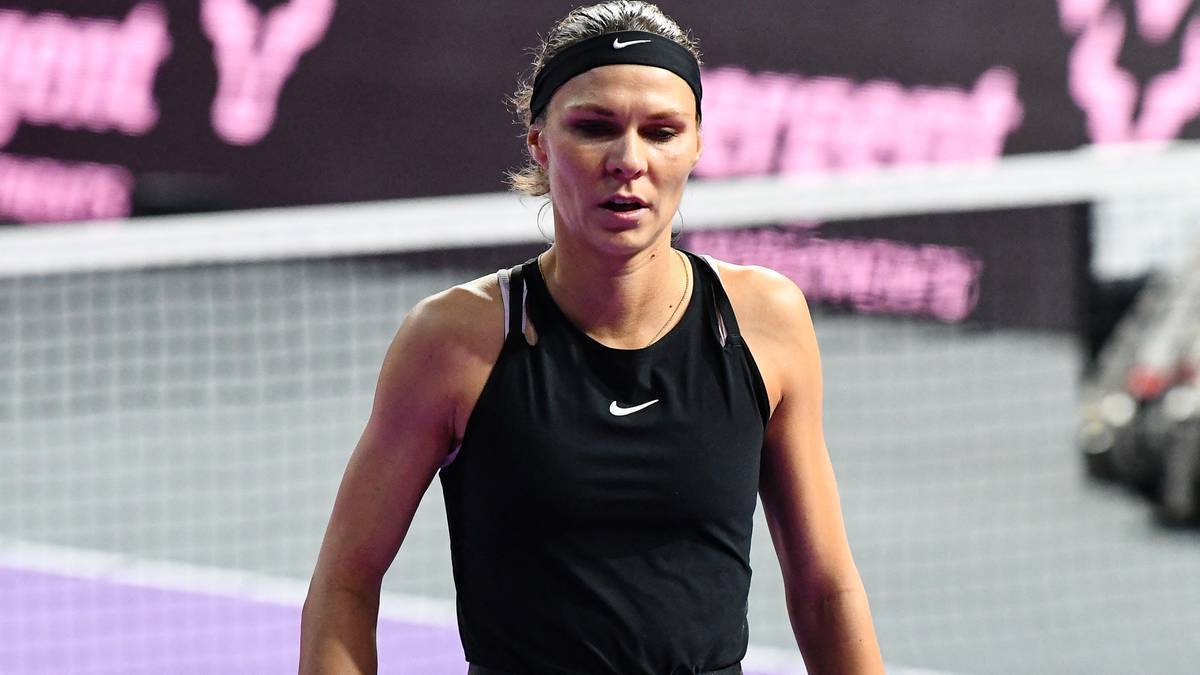 Tenisistka Katarzyna Piter w czarnym stroju sportowym z opaską na czole.