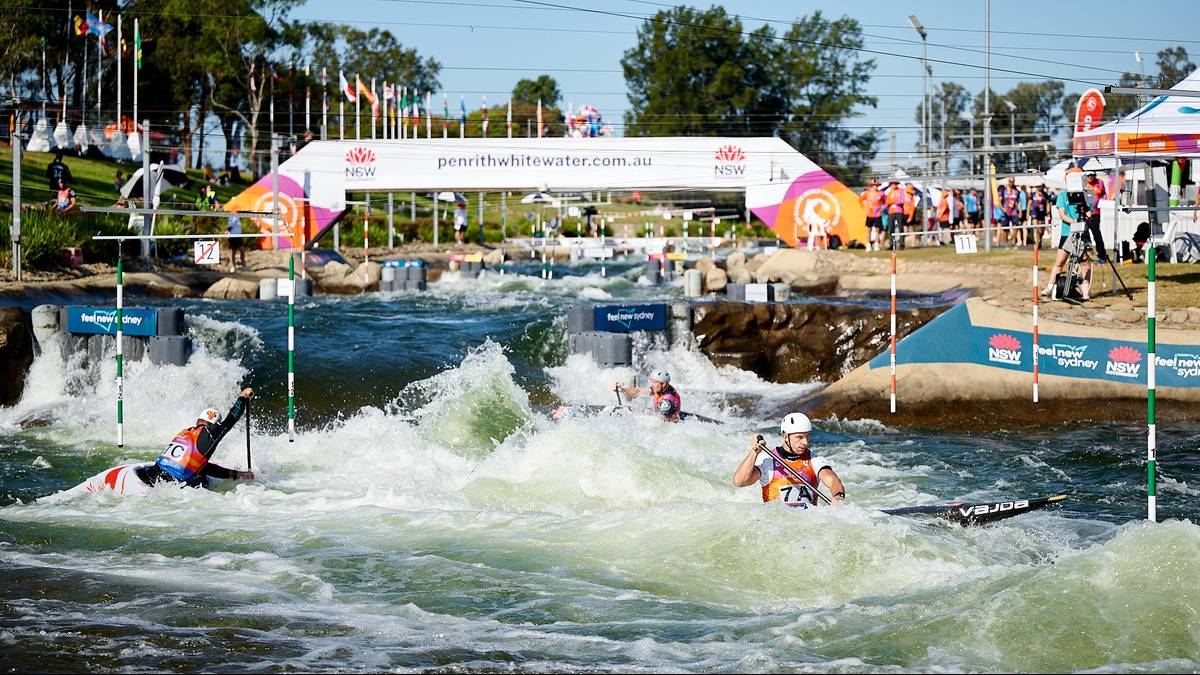 Kajakarze ścigają się po torze z bystrą wodą, mijają bramki i pokonują przeszkody wodne.