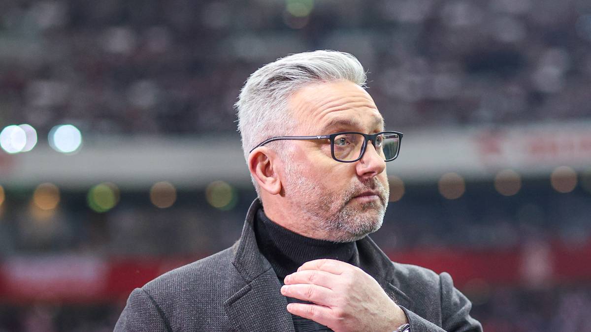 Portret Jerzego Brzęczka, byłego trenera reprezentacji Polski w piłce nożnej, w okularach i ciemnym golfie.