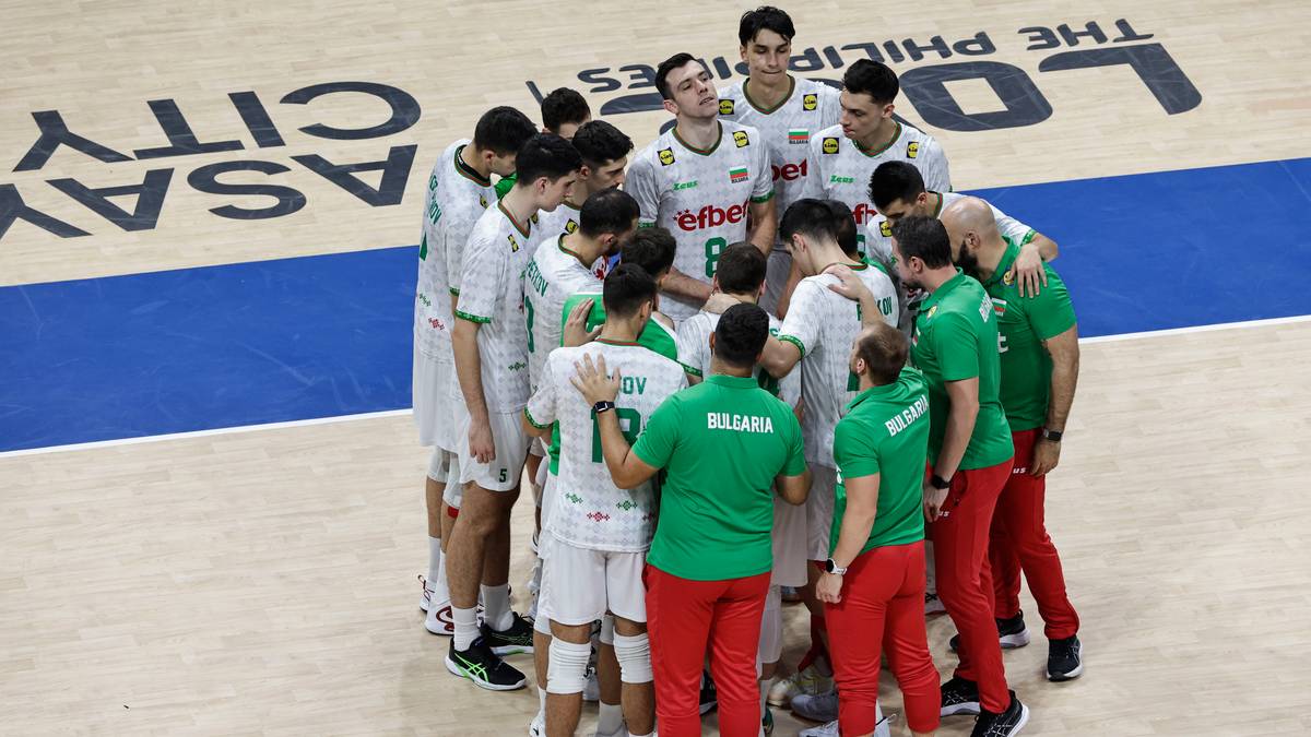 Drużyna siatkarzy w zielonych i białych strojach tworzy kółko na boisku, obejmując się nawzajem.