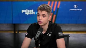 Młody polski medalista olimpijski udziela wywiadu przed mikrofonem. Na jego koszulce widoczne jest logo sportowe.