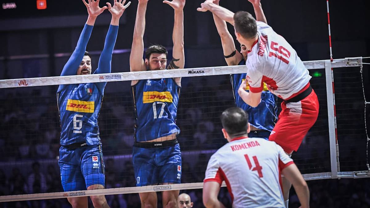 Siatkarze walczą przy siatce, blokując atak przeciwnika podczas meczu.