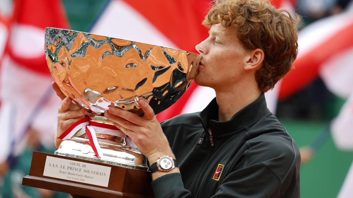 Tenisista całuje puchar po zwycięstwie.