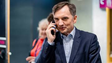 Mężczyzna w garniturze rozmawia przez telefon komórkowy.