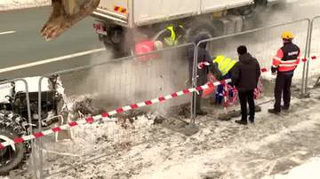 Awaria sieci ciepłowniczej, robotnicy zabezpieczają teren taśmą ostrzegawczą.