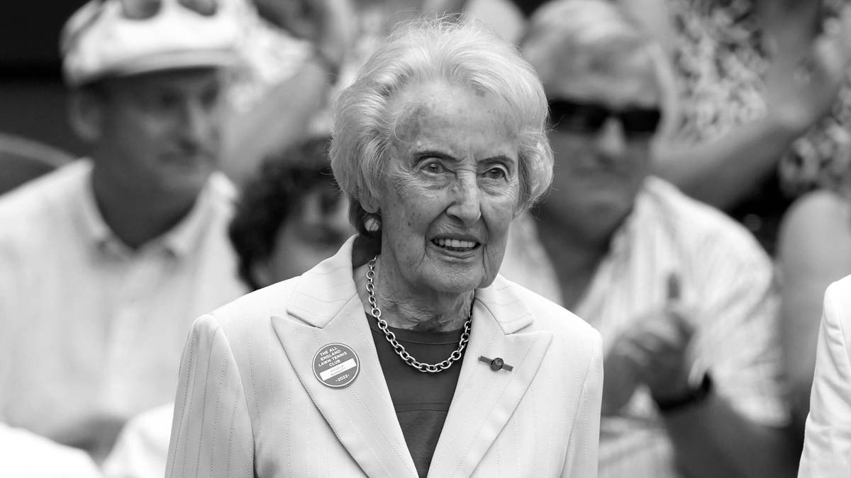 Portret starszej kobiety w eleganckim stroju, noszącej naszyjnik.