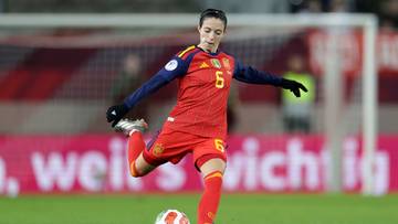 Piłkarka reprezentacji Hiszpanii w czerwonej koszulce z numerem 5 kopie piłkę na boisku.