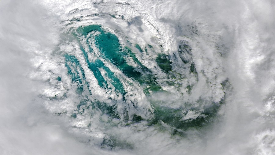 Zdjęcie satelitarne oka huraganu Ian tuż przed uderzeniem we Florydę. Widoczne są białe chmury unoszące się nad zieloną powierzchnią wód Zatoki Meksykańskiej. Fot. NASA.