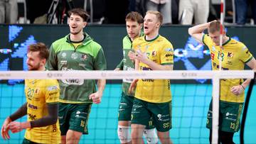 Siatkarze w żółtych i zielonych strojach rywalizują przy siatce.