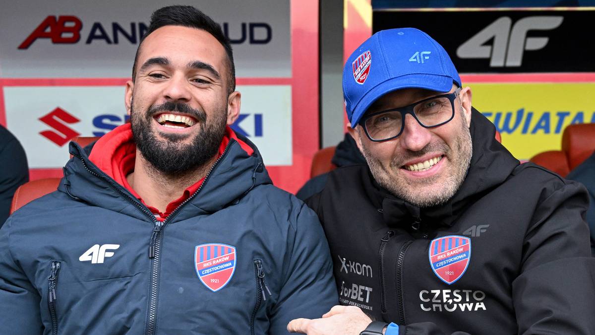 Dwóch mężczyzn w sportowych kurtkach z logiem Rakowa Częstochowa uśmiecha się do kamery.