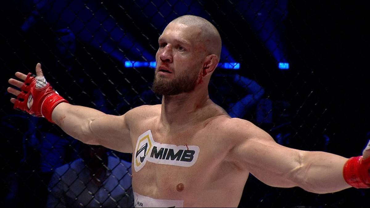 Zawodnik MMA z uniesionymi rękami w ringu.