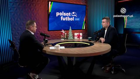 Dw&oacute;ch mężczyzn siedzi naprzeciwko siebie w studiu telewizyjnym, podczas gdy na ekranie za nimi wyświetlane jest logo Polsat Futbol.
