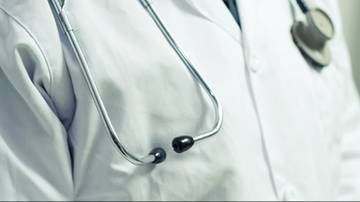 Zbliżenie na biały fartuch lekarski ze stetoskopem, symbolizującym opiekę medyczną.