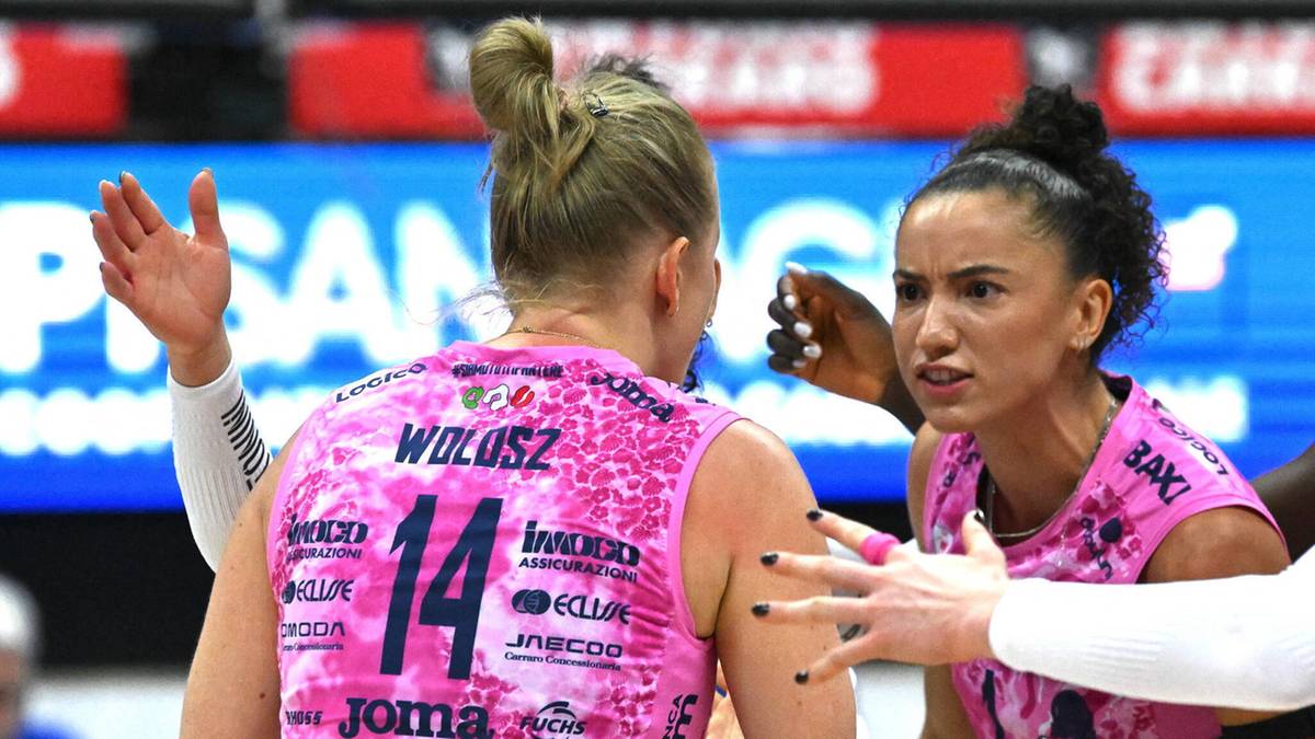 Dwie siatkarki w różowych strojach rozmawiają na boisku podczas meczu.