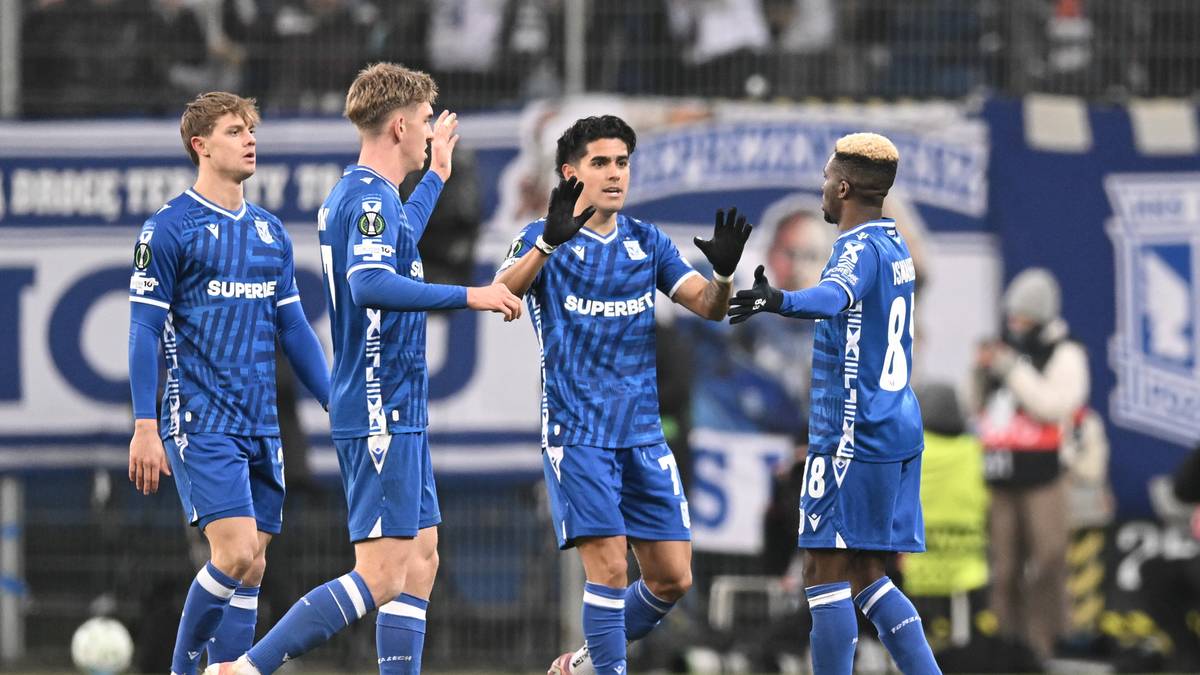 Piłkarze Lecha Poznań w niebieskich strojach świętują razem na boisku.