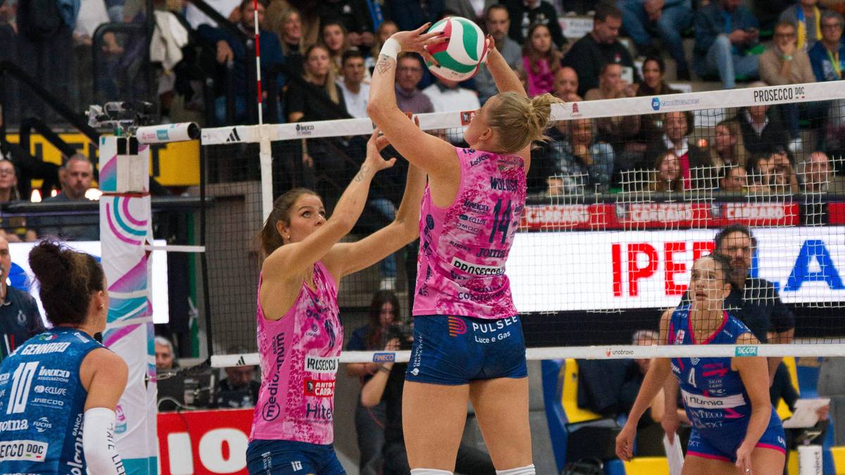 Dwie siatkarki rywalizujące o piłkę podczas meczu siatk&oacute;wki.