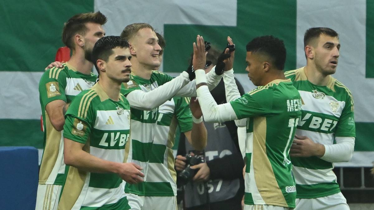 Grupa piłkarzy w zielono-białych strojach świętuje, klaszcząc się nawzajem.