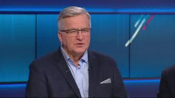 Mężczyzna w okularach i marynarce siedzi podczas debaty.