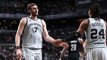 Dw&oacute;ch koszykarzy San Antonio Spurs podaje sobie ręce na boisku podczas meczu.