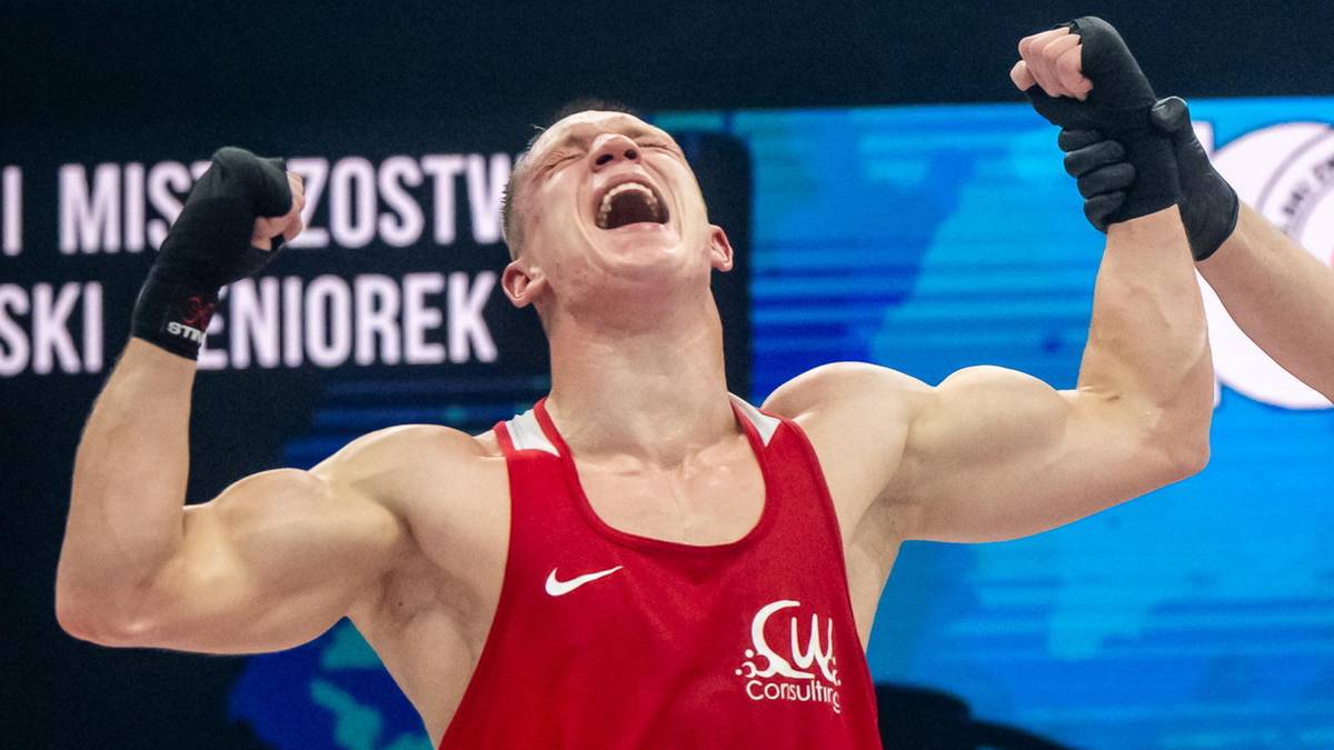 Bokser świętujący zwycięstwo w ringu w obecności sędziego.